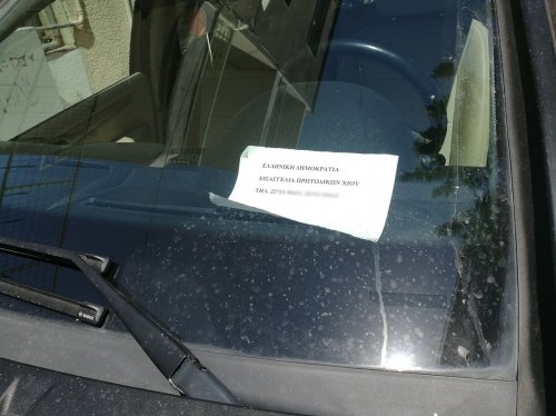 Το ένα από τα οχήματα των Υπαλλήλων της Εισαγγελίας Χίου. Σε ένα πρόχειρο χαρτί ο οδηγός του οχήματος επικαλείται την Ελληνική Δημοκρατία και αναφέρει τα τηλέφωνα της υπηρεσίας του. 